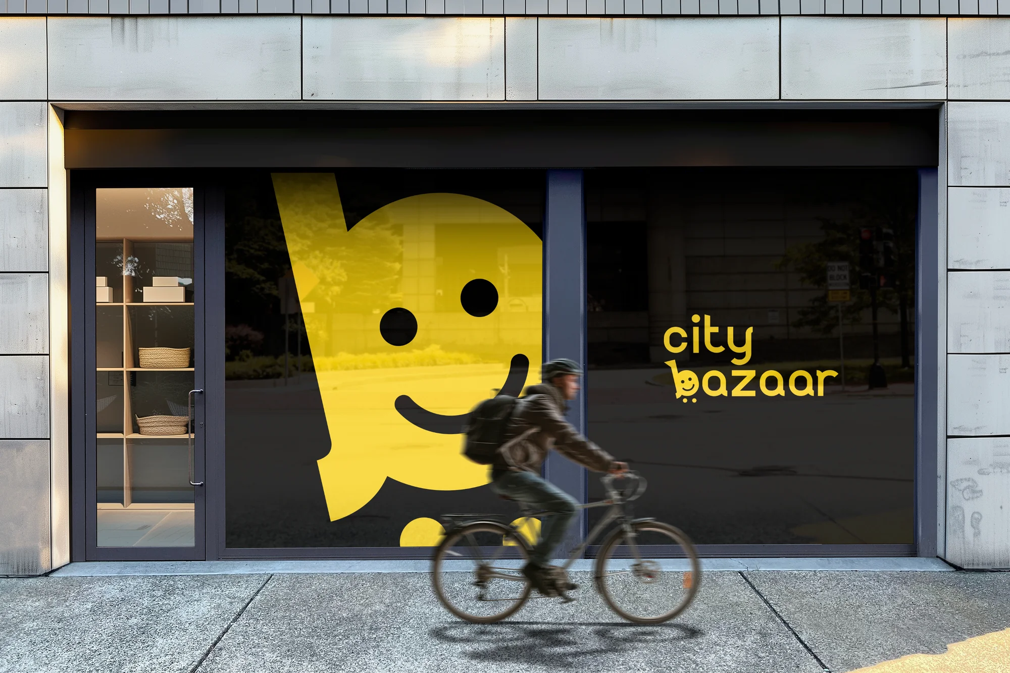 Large yellow CityBazaar smile-cart logo filling a store window, with a cyclist passing by